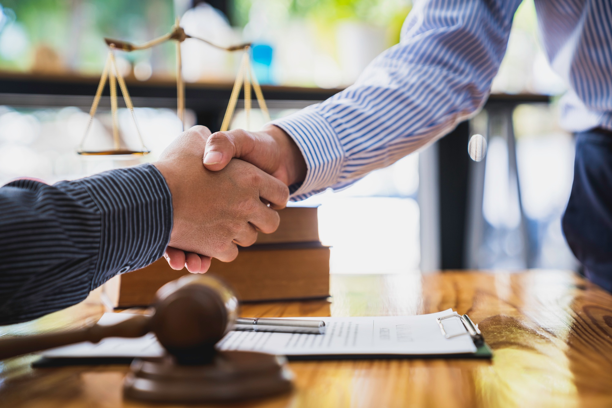 Lawyers shake hands with business people to seal a deal with partner lawyers. or a lawyer discussing
